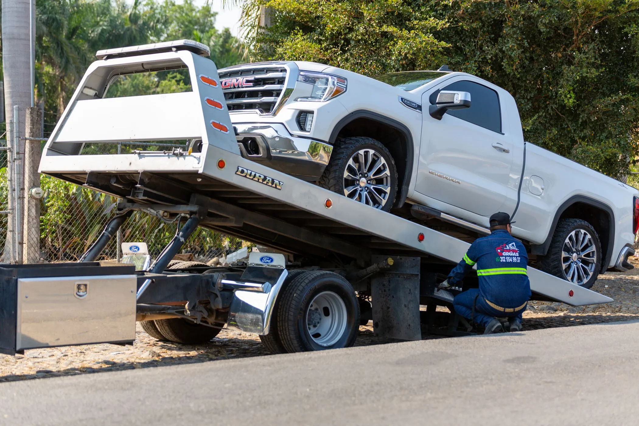 A pickup being loaded onto a flatbed tow truck